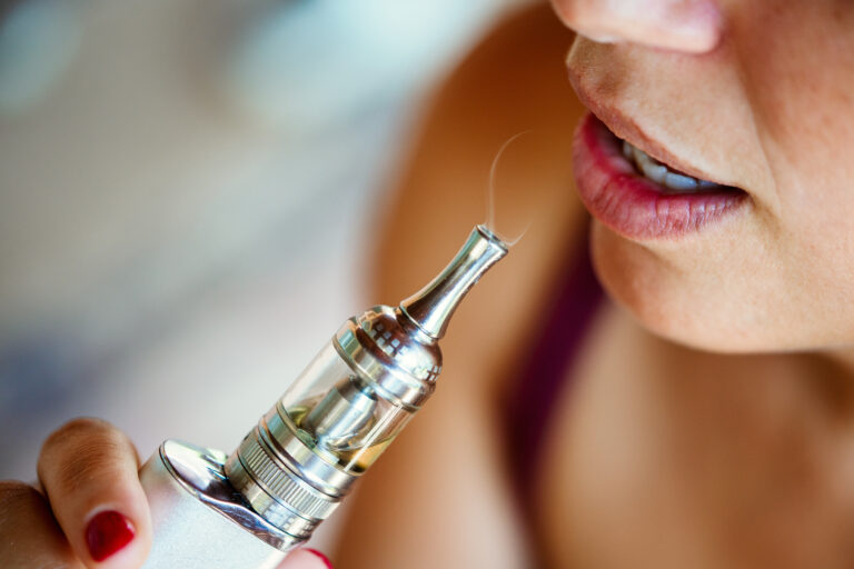 woman smoking an e-cigarette vape