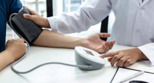 photo of a dentist checking a dental patient's blood pressure